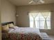Well-lit bedroom featuring floral bedding, a ceiling fan, and a large window with blinds at 1659 Harris St, Superior, CO 80027
