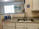 The kitchen area features a stainless steel sink, granite countertop, and white cabinets for ample storage and functionality at 1659 Harris St, Superior, CO 80027