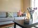 Cozy living room showcasing a gray sofa, decorative cushions, flowers, and a black coffee table with charming decor at 1659 Harris St, Superior, CO 80027
