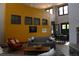 This welcoming living room boasts high ceilings, a cozy grey sofa, a vibrant orange accent chair, and artistic wall decor at 1659 Harris St, Superior, CO 80027
