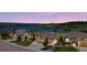 Scenic view of homes near a lake, showcasing landscaping and neighborhood charm under a colorful sky at 3255 Waterfront Dr, Monument, CO 80132