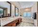 Well-lit bathroom featuring double sinks, a soaking tub, and decorative tile backsplash at 8216 S Krameria Way, Centennial, CO 80112