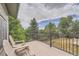 Elevated deck showcasing outdoor seating, a metal railing, and views of lush green trees at 8216 S Krameria Way, Centennial, CO 80112