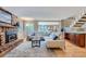 Bright living room with fireplace, hardwood floors, and open view to kitchen and staircase at 8216 S Krameria Way, Centennial, CO 80112