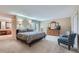 Comfortable main bedroom with carpet, double sconces and a dresser with mirror and tv at 8216 S Krameria Way, Centennial, CO 80112