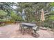 Outdoor patio features a dining table and chairs surrounded by lush greenery and trees at 8216 S Krameria Way, Centennial, CO 80112