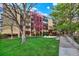 This tan brick apartment building features a well maintained lawn and mature trees at 7040 E Girard Ave # 406, Denver, CO 80224