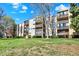 The apartment building is surrounded by an expansive lawn, mature trees and lush greenery at 7040 E Girard Ave # 406, Denver, CO 80224