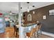 Eat-in kitchen area featuring stylish lighting, breakfast bar and adjacent dining space at 7040 E Girard Ave # 406, Denver, CO 80224