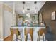 Eat-in kitchen area featuring stylish lighting, breakfast bar and vintage cabinets at 7040 E Girard Ave # 406, Denver, CO 80224