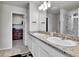 Bathroom featuring a double sink vanity with granite counters, a large mirror and tile flooring at 6459 N Dunkirk St, Denver, CO 80249