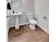 This bathroom features a pedestal sink, a white toilet, and modern fixtures at 6459 N Dunkirk St, Denver, CO 80249