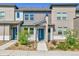 Modern townhome with a blue front door, landscaped yard, and neutral colored exterior at 6459 N Dunkirk St, Denver, CO 80249