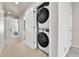 Hallway with stacked laundry units and a view to a bright bedroom at 6459 N Dunkirk St, Denver, CO 80249