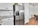 Modern kitchen with stainless steel refrigerator, white cabinetry, and granite countertops at 6459 N Dunkirk St, Denver, CO 80249
