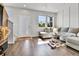Sunlit living room featuring hardwood floors, a gray sectional sofa, and large windows at 6459 N Dunkirk St, Denver, CO 80249