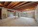 Unfinished basement featuring exposed beams, concrete walls, and a staircase at 10524 Serengeti Dr, Lone Tree, CO 80124