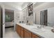 Bright bathroom featuring double sinks, vanity with cabinets, large mirrors, and access to the bedroom at 10524 Serengeti Dr, Lone Tree, CO 80124