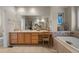 A bathroom features a soaking tub, vanity, and neutral tile at 10524 Serengeti Dr, Lone Tree, CO 80124