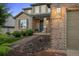 Home's entrance showcases brick accents and manicured landscaping at 10524 Serengeti Dr, Lone Tree, CO 80124