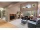 Bright living room features a cozy fireplace, large windows, and a soaring ceiling at 10524 Serengeti Dr, Lone Tree, CO 80124