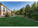 Lush backyard with green lawn, mature trees, and manicured landscaping at 27235 E Lakeview Pl, Aurora, CO 80016