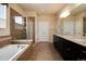 Main bathroom featuring a double vanity, soaking tub, and glass shower with tile surround at 27235 E Lakeview Pl, Aurora, CO 80016