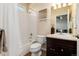 Bright bathroom with a tub/shower combo, dark wood vanity, and decorative wall accents at 27235 E Lakeview Pl, Aurora, CO 80016