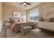 Bright bedroom featuring a padded headboard, a sitting bench, and a large window for ample natural light at 27235 E Lakeview Pl, Aurora, CO 80016