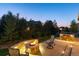 Outdoor fire pit area with built-in seating and professional landscape lighting at dusk at 27235 E Lakeview Pl, Aurora, CO 80016