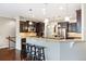 Open-concept kitchen featuring dark cabinetry, granite countertops, stainless steel appliances, and hardwood floors at 27235 E Lakeview Pl, Aurora, CO 80016