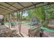 Relaxing covered patio in a backyard with a trampoline, swings, grill, and outdoor seating for entertaining guests at 1817 S Perry Way, Denver, CO 80219