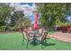 The backyard is turfed and furnished with a dining set, an umbrella, and a trampoline at 1817 S Perry Way, Denver, CO 80219
