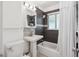 Bathroom featuring a pedestal sink, tiled walls, and a combined tub and shower with a white shower curtain at 1817 S Perry Way, Denver, CO 80219