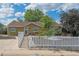 Charming single-story home featuring a welcoming entrance, white picket fence, and well-maintained landscaping at 1817 S Perry Way, Denver, CO 80219