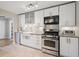 Modern kitchen featuring white cabinets, stainless steel appliances, and granite countertops with a farmhouse sink at 1817 S Perry Way, Denver, CO 80219