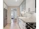 Bright kitchen featuring stainless steel appliances, a farmhouse sink, and gray granite countertops at 1817 S Perry Way, Denver, CO 80219