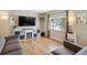 Cozy living room featuring hardwood floors, a gray sofa, and a modern entertainment center with a fireplace at 1817 S Perry Way, Denver, CO 80219