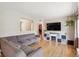 Bright living room featuring hardwood floors, a gray sofa, and a modern entertainment center with a fireplace at 1817 S Perry Way, Denver, CO 80219