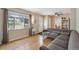 Inviting living room featuring hardwood floors, a gray sectional sofa, and a window with natural light at 1817 S Perry Way, Denver, CO 80219