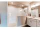 Modern bathroom featuring a spacious walk-in shower with white subway tile and a well-lit vanity at 9571 Yucca Ct, Arvada, CO 80007