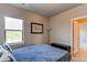 This bedroom features a bright window, a modern lamp, and a neutral color palette at 9571 Yucca Ct, Arvada, CO 80007