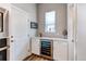 Functional butler's pantry featuring built-in wine cooler, counter space, and ample storage cabinets at 9571 Yucca Ct, Arvada, CO 80007
