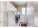 Bright laundry room with modern washer, dryer, and ample storage at 9571 Yucca Ct, Arvada, CO 80007