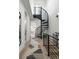 Spacious hall with spiral staircase, wood floors, and modern railings leading to adjacent rooms at 2012 W 46Th Ave, Denver, CO 80211