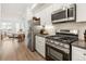 Modern kitchen featuring stainless steel appliances, white cabinets, and open concept design at 2012 W 46Th Ave, Denver, CO 80211