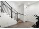 Modern staircase with black railings, wood treads, and a lower-level view with workout equipment at 2012 W 46Th Ave, Denver, CO 80211