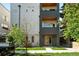 Contemporary multi-story townhome with light gray stucco, dark accents, landscaping, and a pop of color at 2830 W 32Nd Ave, Denver, CO 80211