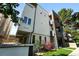 Modern, multi-story townhome with gray stucco, dark accents, landscaping, and a touch of greenery at 2830 W 32Nd Ave, Denver, CO 80211