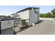 A rooftop deck with gray outdoor flooring, a modern white structure, and black metal fencing against a blue sky at 2830 W 32Nd Ave, Denver, CO 80211